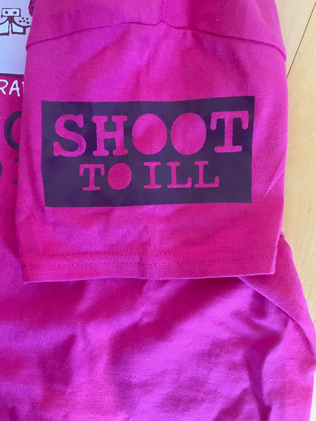Image of the right sleeve of the shirt. Has a cutout of the SHOOT TO ILL text.